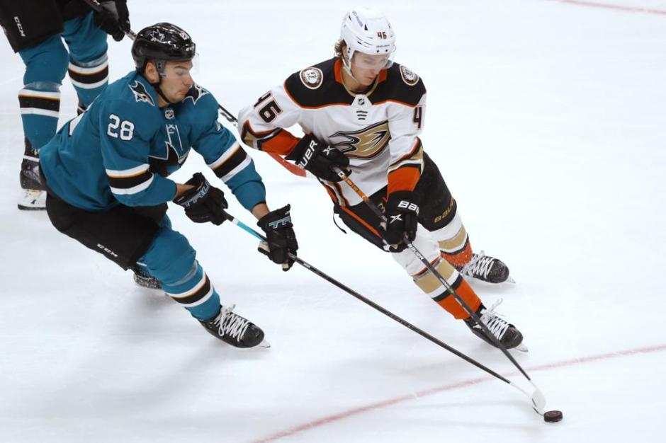Anaheim Ducks forward Sam Carrick, center, and San Jose Sharks defenseman  Jacob Middleton, right, fight during the first period of an NHL hockey game  Sunday, Sept. 26, 2021, in Anaheim, Calif. (AP